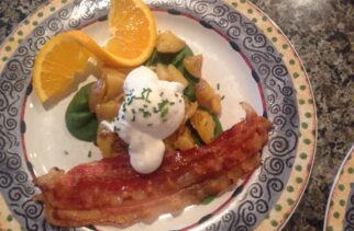 Poached Egg on top of Herbed Potatoes, Bacon and an Orange